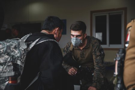 A Marine assigned to the 24th Marine Expeditionary Unit (MEU) processes an evacuee at Hamid Karzai International Airport, in Kabul, Afghanistan, Sunday, Aug. 15, 2021.