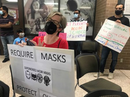 Parent Kirsten Hussenoeder sits at a silent protest before a Fort Bend County ISD vote on mask mandates, on Aug. 23, 2021. Hussenoeder said she was in support of mandating masks in schools.