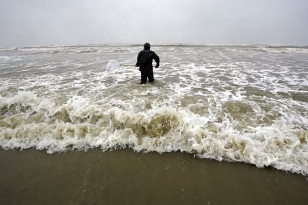 Daniel fishes in the Gulf of Mexico as winds from what was Hurricane Nicholas continue to push waves closer to shore Tuesday, Sept. 14, 2021, in Galveston, Texas.