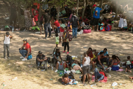 Asylum-seeking migrants rest under the International Bridge in Del Rio between Mexico and the U.S. on Sept. 15, 2021. The sheriff in Val Verde County estimates that about 70% of the migrants are from Haiti.