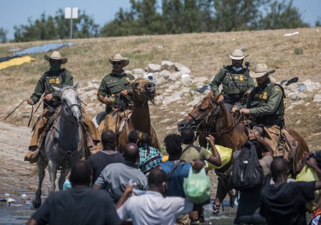 U.S. Customs and Border Protection mounted officers attempt to contain migrants as they cross the Rio Grande from Ciudad Acuña, Mexico, into Del Rio, Texas, Sunday, Sept. 19, 2021. Thousands of Haitian migrants have been arriving to Del Rio, Texas, as authorities attempt to close the border to stop the flow of migrants.