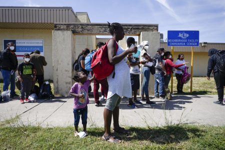 Migrants, many from Haiti, wait to board a bus to Houston at a humanitarian center after they were released from United States Border Patrol upon crossing the Rio Grande and turning themselves in seeking asylum, Wednesday, Sept. 22, 2021, in Del Rio, Texas.