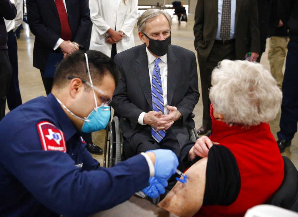 Texas Governor Greg Abbott (center) visits with Barbara Alexander of Bedford as she receives her COVID-19 shot from Arlington firefighter Andrew Harris at a mass vaccination site inside the Esports Stadium Arlington &amp; Expo Center in Arlington, Texas, Monday, January 11, 2021. Alongside local and state officials, Abbott provided an update on COVID-19 vaccine efforts in Texas.