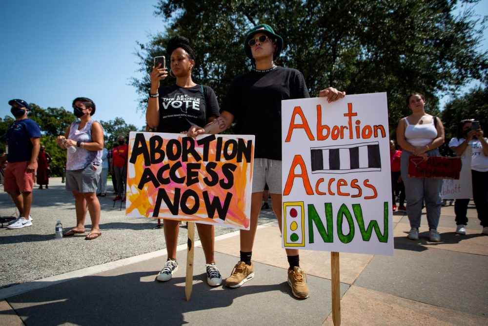 Ishia Lynette and Namdie Adams hold signs in support of abortion rights at a rally outside the Texas Capitol on Sept. 11.