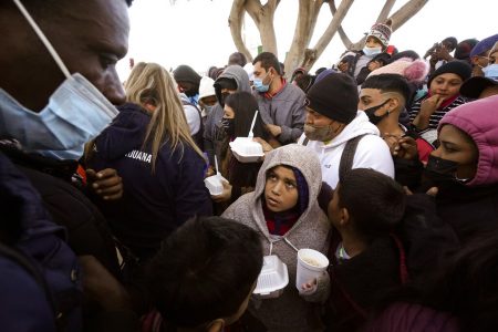 In this Friday, Feb. 19, 2021, file photo, asylum seekers receive food as they wait for news of policy changes at the border, in Tijuana, Mexico.   A federal appellate court refused late Thursday, Aug. 19 to delay implementation of a judge’s order reinstating a Trump administration policy forcing thousands to wait in Mexico while seeking asylum in the U.S. President Joe Biden had suspended former President Donald Trump’s “Remain in Mexico” policy on his first day in office and the Department of Homeland Security said it was permanently terminating the program in June, according to the court record.