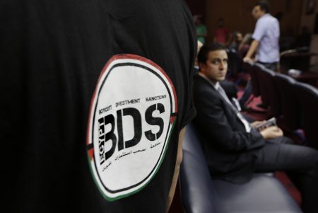 An Egyptian wears a T-shirt with the Boycott, Divestment and Sanctions (BDS) logo during the launch of the Egyptian campaign that urges boycott, divestment and sanctions against Israel and Israeli-made goods, at the Egyptian Journalists Syndicate in Cairo, Egypt on Monday, April 20, 2015. BDS is a global movement initiated by Palestinian civil society activists in 2005 that organizers say will continue until Israel complies with international law and respects Palestinian rights.