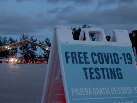 Healthcare workers in Miami,  Florida, administer COVID-19 tests at a 24-hour drive-through site set up by Miami-Dade County and Nomi Health on August 30, 2021.