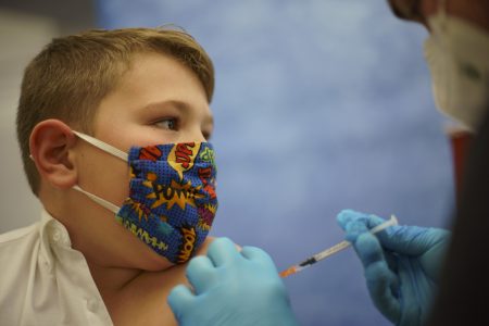 Mikey Farias, 10, receives the Pfizer-BioNTech COVID-19 vaccine for children ages 5-11 at a state-run site in Cranston, R.I., Thursday, Nov. 4, 2021.