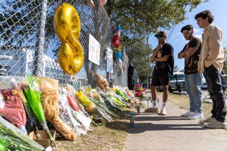 Mourners stand outside a makeshift memorial at NRG Park, where on Friday eight people were killed when the crowd at the Astroworld Festival rushed toward the stage for rapper Travis Scott's set.
