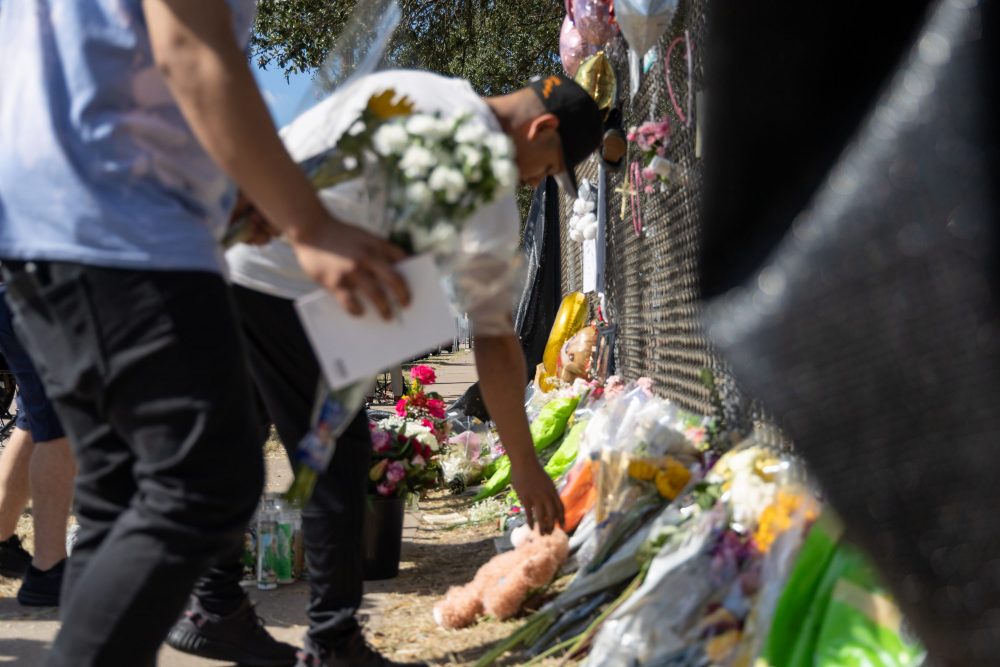 A mourner leaves flowers at a memorial for Astroworld victims outside NRG Park on Nov. 9, 2021.
