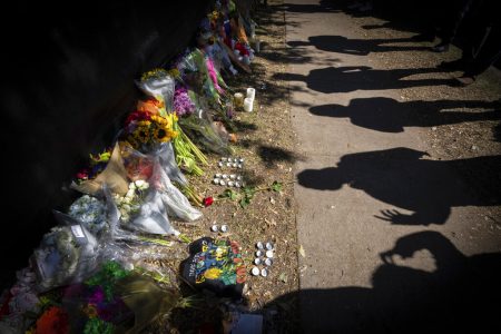 Visitors cast shadows at a memorial to the victims of the Astroworld concert in Houston on Sunday, Nov. 7, 2021.