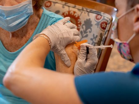 A health care worker administers a third dose of the Pfizer-BioNTech COVID-19 vaccine at a senior living facility in Worcester, Pennsylvania, in August.