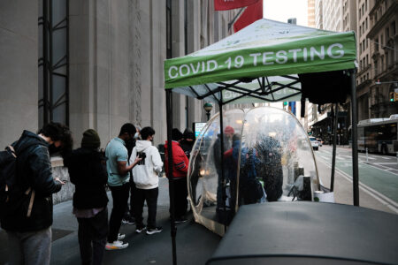 NEW YORK, NEW YORK - NOVEMBER 29: People line-up to take a Covid test at a site in Manhattan on November 29, 2021 in New York City. Across New York City and the nation, people are being encouraged to get either the booster shot or the Covid-19 vaccine, especially with the newly discovered omicron variant slowly emerging in countries around the world. While there are no cases yet discovered in America, New York's governor Kathy Hochul has declared a state of emergency ahead of the risk of COVID-19 spikes as winter sets in. (Photo by Spencer Platt/Getty Images)