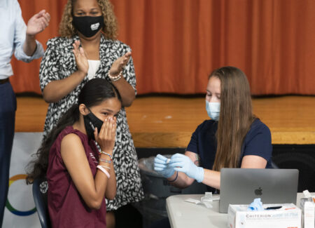 Ariel Quero, 16, left, a student at Lehman High School, reacts after getting the Pfizer COVID-19 vaccine from Katrina Taormina, right, July 27, 2021, in New York. The U.S. is expanding COVID-19 boosters, ruling that 16- and 17-year-olds can get a third dose of Pfizer’s vaccine. The U.S. and many other nations already were urging adults to get booster shots to pump up immunity that can wane months after vaccination, calls that intensified with the discovery of the worrisome new omicron variant. On Thursday, Dec. 9, 2021 the FDA gave emergency authorization for 16- and 17-year-olds to get a third dose of the vaccine made by Pfizer and its partner BioNTech -- if it’s been six months since their last shot.