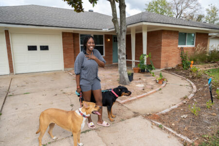 Loyce Gayo in front of her home with her two dogs on Dec. 17, 2021.