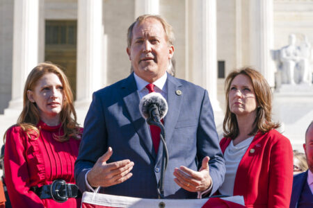 Texas State Rep. Shelby Slawson, left, and Texas State Sen. Angela Paxton, right, listen as Texas Attorney General Ken Paxton, center, speaks to anti-abortion activists at a rally outside the Supreme Court, Monday, Nov. 1, 2021, on Capitol Hill in Washington.