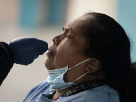 Leticia Lopez is tested for COVID-19 at a pop-up testing and vaccination site outside a swap meet in Los Angeles.