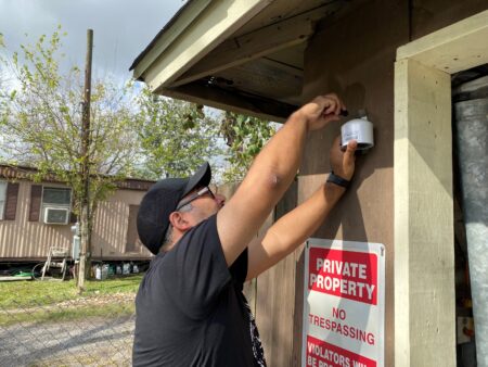 Juan Flores with Air Alliance Houston installs a PurpleAir monitor at a home in Jacinto City.