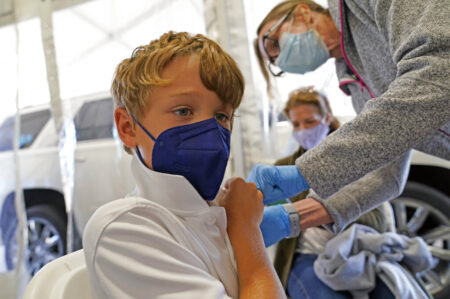 Max Betasso, 8, receives the Pfizer COVID-19 vaccine for children five to 12 years from Dallas County Health and Human Services nurse Shari Yarto at a vaccination site in Mesquite, Texas, Thursday, Nov. 4, 2021.