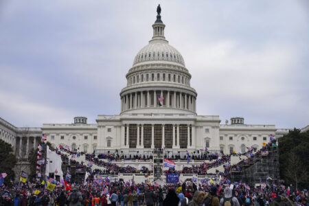 Insurrectionists loyal to then-President Donald Trump are seen swarming the U.S. Capitol on Jan. 6, 2021, in Washington, D.C. Americans remain bitterly divided over the events that led to the siege on the Capitol that day, according to a new NPR/Ipsos poll.