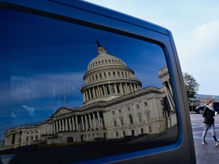 A reflection of the US Capitol on a car window on January 13, 2022, in Washington, DC. - US President Joe Biden will meet with the Senate Democratic Caucus to discuss the passing of legislation to protect the constitutional right to vote and the integrity of  elections.