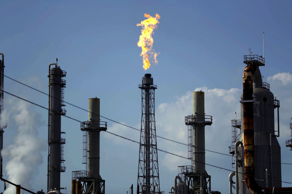 In this Thursday, Aug. 31, 2017, file photo, a flame burns at the Shell Deer Park oil refinery in Deer Park, Texas. The price of crude oil barely moved in 2017, and energy companies faded after a big gain the year before.