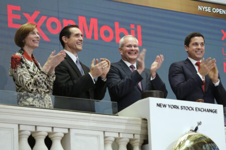 In this Wednesday, March 1, 2017, file photo, Exxon Mobil Corporation Chairman & CEO Darren Woods, third from left, joins the applause during opening bell ceremonies at the New York Stock Exchange. Woods succeeded Rex Tillerson, following Tillerson's nomination by President Donald Trump to be the next United States Secretary of State. Woods is a veteran of the more cautious refining side of the oil business who is likely to focus relentlessly on controlling costs.