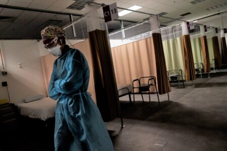 FILE - In this Wednesday, Feb. 10, 2021 file photo, traveling registered nurse Patricia Carrete, of El Paso, Texas, walks down the hallways during a night shift at a field hospital set up to handle a surge of COVID-19 patients in Cranston, R.I.