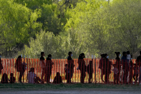 In this March 19, 2021, file photo, migrants are seen in custody at a U.S. Customs and Border Protection processing area under the Anzalduas International Bridge, in Mission, Texas. U.S. authorities say they picked up nearly 19,000 children traveling alone across the Mexican border in March. It's the largest monthly number ever recorded and a major test for President Joe Biden as he reverses many of his predecessor's hardline immigration tactics.