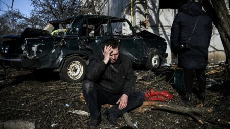 A man sits outside his destroyed building after bombings on the eastern Ukraine town of Chuguiv on February 24, 2022, as Russian armed forces are trying to invade Ukraine from several directions, using rocket systems and helicopters to attack Ukrainian position in the south, the border guard service said. - Russia's ground forces on Thursday crossed into Ukraine from several directions, Ukraine's border guard service said, hours after President Vladimir Putin announced the launch of a major offensive. Russian tanks and other heavy equipment crossed the frontier in several northern regions, as well as from the Kremlin-annexed peninsula of Crimea in the south, the agency said.