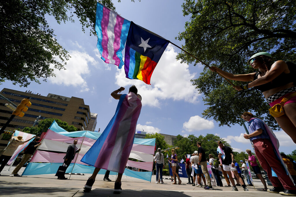 In this Thursday, May 20, 2021 file photo, demonstrators gather on the steps to the State Capitol to speak against transgender-related legislation bills being considered in the Texas Senate and Texas House in Austin, Texas. Pride Month celebrations in the U.S. are taking place under unusual circumstances in June 2021, with pandemic-related concerns disrupting many of the usual festivities and political setbacks dampening the mood of LGBTQ-rights activists.