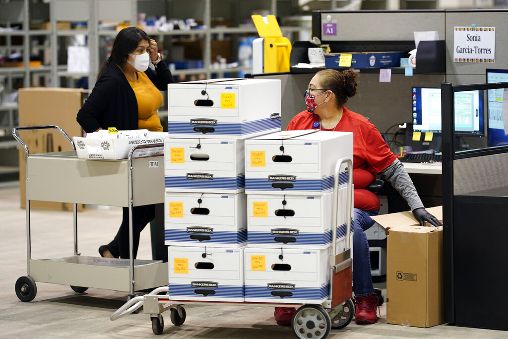 Harris County election workers handle mail-in ballots at election headquarters Tuesday, Sept. 29, 2020, in Houston.