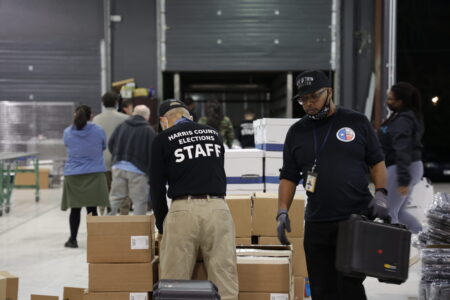 Harris County election workers handle ballots Tuesday, March 1, 2022. State officials say the county won't be able to report results within the statutory 24-hour window after Election Day.