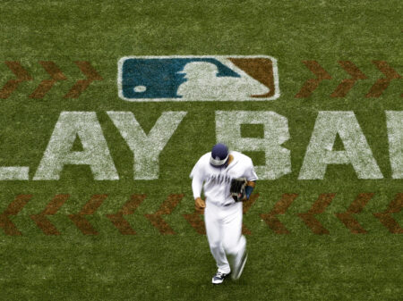 San Diego Padres left fielder Allen Cordoba passes a logo for Play Ball, an initiative from Major League Baseball and USA Baseball, during the fifth inning of a baseball game against the Colorado Rockies on June 3, 2017, in San Diego. Players voted Thursday, March 10, 2022, to accept MLB's offer on new labor deal, paving way to end 99-day lockout and salvage 162-game season.