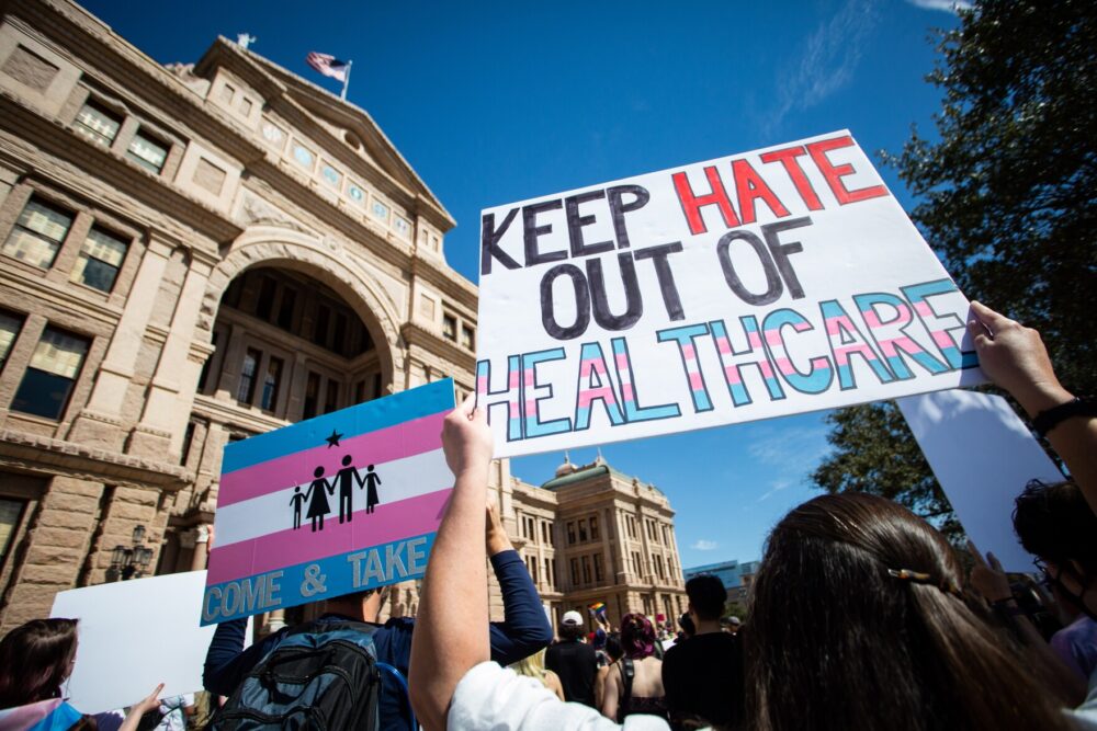 Demonstrators hold signs in support of transgender youth outside the Texas Capitol on March 1 in response to proposed legal action against parents seeking gender-affirming health care for their children.