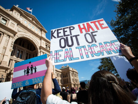 Demonstrators hold signs in support of transgender youth and rights in response to recent proposed legal action against parents seeking gender affirming healthcare for their children to be charged as child abuse at the Rally for Trans Youth at the Texas State Capitol earlier this month.