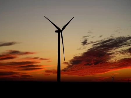 A wind turbine is silhouetted against the sky at sunset near Ellsworth, Kansas. The 300-foot-tall turbine is among the 134 units that make up the Post Rock Wind Farm.