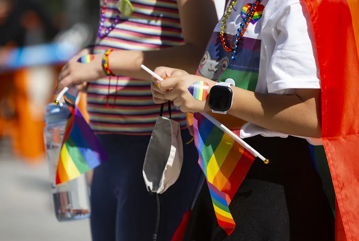 Kids hold flags and wear heart stickers and beads at the Austin Independent School District’s “Pride Out!” party in Austin last month. Lt. Gov. Dan Patrick wants a Texas law similar to Florida legislation limiting classroom lessons about LGBTQ people.
