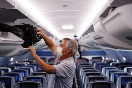 FILE - In this May 28, 2020, file photo, a passenger wears personal protective equipment on a Delta Airlines flight.