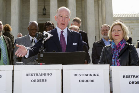 Dr. Steven Hotze, president of Conservative Republicans of Texas, speaks at a Restrain the Judges news conference, while Janet Porter of Faith2Action listens at right, in front of the Supreme Court in Washington, Monday, April 27, 2015. The opponents of same-sex marriage are urging the court to resist embracing what they see as a radical change in society's view of what constitutes marriage.