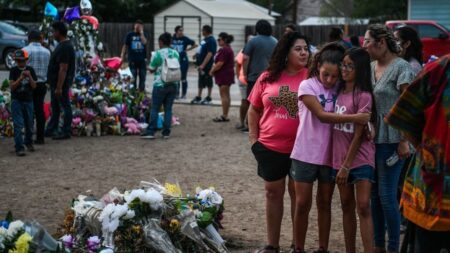 People mourn at a makeshift memorial for the victims of the Robb Elementary School shooting in Uvalde, Texas, May 31, 2022. - The traumatized Texas town of Uvalde began on Tuesday laying to rest the 19 young children killed in an elementary school shooting that left the small, tight-knit community united in grief and anger. (Photo by CHANDAN KHANNA / AFP) (Photo by CHANDAN KHANNA/AFP via Getty Images)