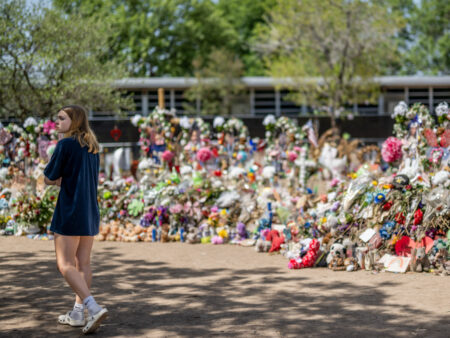 UVALDE, TEXAS - JUNE 17: Olivia Luna, 15, pays her respects at a memorial in front of Robb Elementary School on June 17, 2022 in Uvalde, Texas. Committees have begun inviting testimony from law enforcement authorities, family members and witnesses regarding the mass shooting at Robb Elementary School which killed 19 children and two adults. Because of the quasi-judicial nature of the committee's investigation and pursuant to House, Section 12, witnesses will be examined in executive session. (Photo by Brandon Bell/Getty Images)