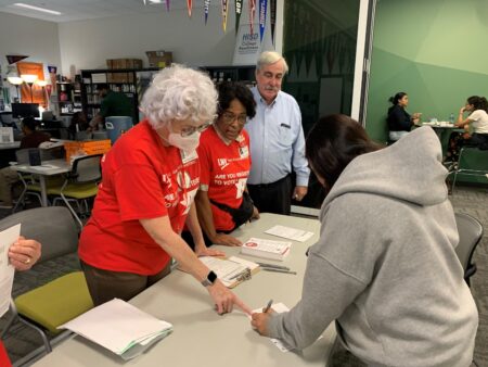 Ann Brooks, left, a volunteer with the League of Women Voters of Houston, helps an Austin High School student register to vote during an outreach initiative on the campus Thursday, Aug. 25, 2022.