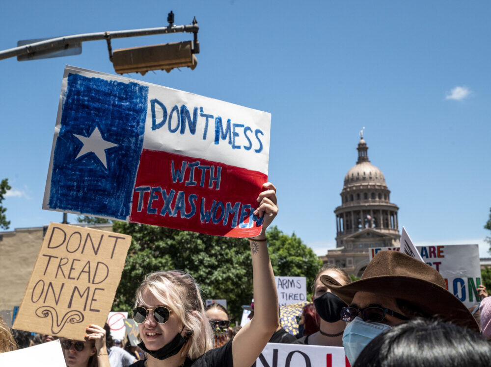 AUSTIN, TX - MAY 29: Protesters hold up signs as they march down Congress Ave at a protest outside the Texas state capitol on May 29, 2021 in Austin, Texas. Thousands of protesters came out in response to a new bill outlawing abortions after a fetal heartbeat is detected signed on Wednesday by Texas Governor Greg Abbot. (Photo by Sergio Flores/Getty Images)