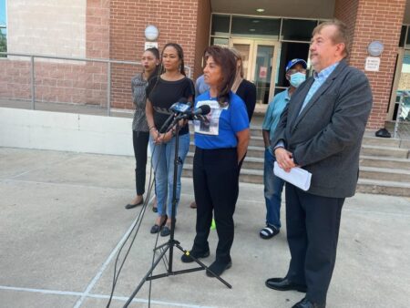 Fred Harris's mother (black top), grandmother (blue shirt) and the family's attorney speak at a press conference.