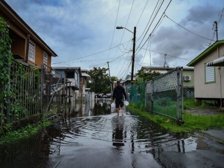 A man walks down a flooded street in the Juana Matos neighborhood of Catano, Puerto Rico, on September 19, 2022, after the passage of Hurricane Fiona. - Hurricane Fiona smashed into Puerto Rico, knocking out the US island territory's power while dumping torrential rain and wreaking catastrophic damage before making landfall in the Dominican Republic on September 19. (Photo by AFP) (Photo by -/AFP via Getty Images)