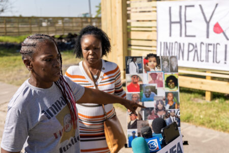 Fifth Ward residents gather on Lavender Street near a poster of those who've died or been hospitalized due to cancer-related illnesses. Taken on September 29, 2022.