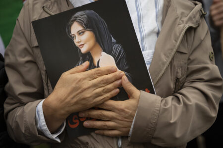Portrait of Mahsa Amini is held during a rally calling for regime change in Iran. Photo by Cliff Owen