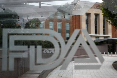 FILE - In this Aug. 2, 2018, file photo, the U.S. Food and Drug Administration (FDA) building is visible behind FDA logos at a bus stop on the agency's campus in Silver Spring, Md. The U.S. Food and Drug Administration has for the first time approved a video game for treating attention deficit hyperactivity disorder in children. The FDA said Monday, June 15, 2020, the game built by Boston-based Akili Interactive Labs can improve attention function. (AP Photo/Jacquelyn Martin, File)