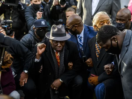 Attorney Ben Crump (center) took a knee with members of George Floyd's family and Rev. Al Sharpton for 8 minutes and 46 seconds outside the Hennepin County Government Center in Minneapolis, Minn., shortly before opening arguments began in the trial of former police officer Derek Chauvin.